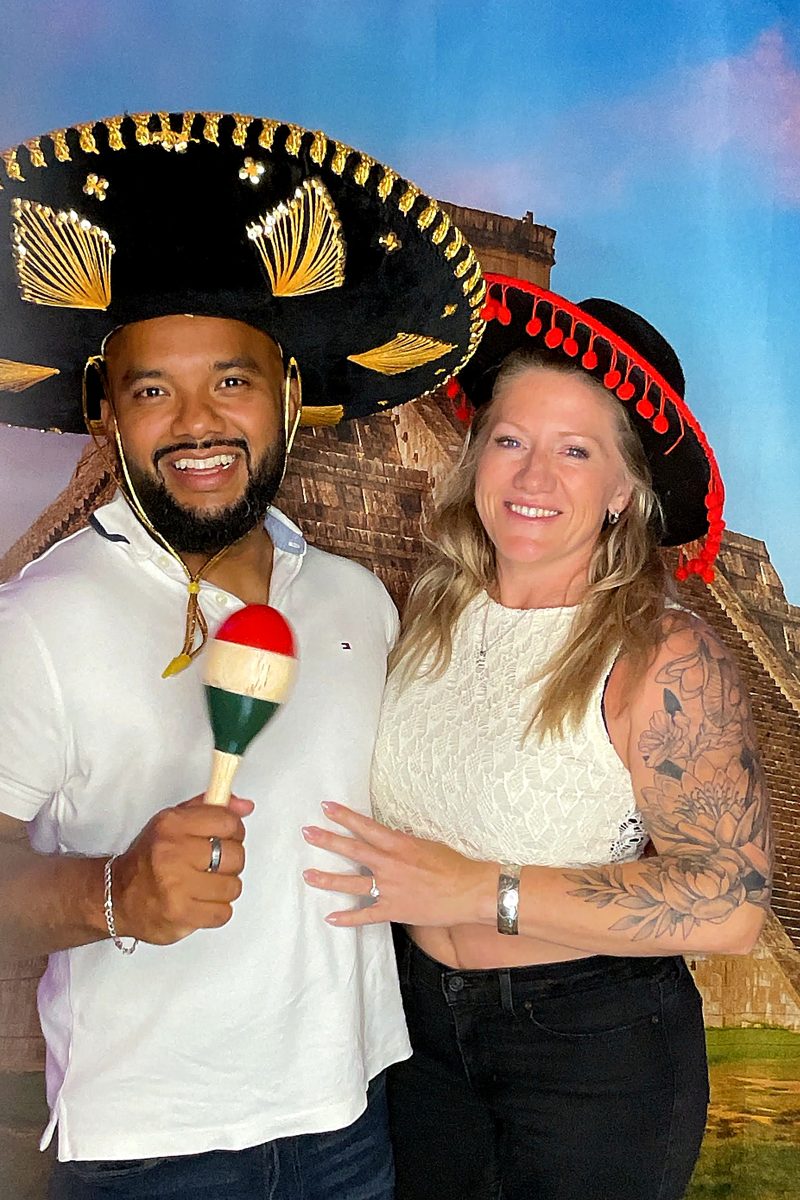 A smiling couple in sombreros at the photo booth